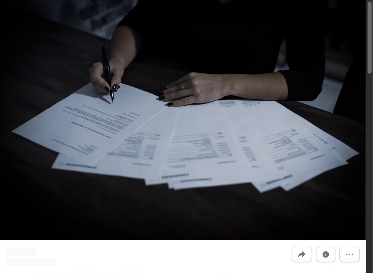 A person signing benefits paperwork spread across a desk, representing negotiating benefits beyond salary