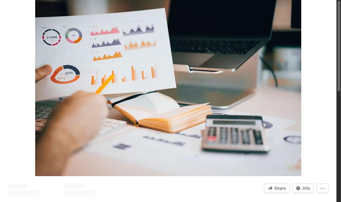 Person analyzing business charts and graphs at a desk with a laptop