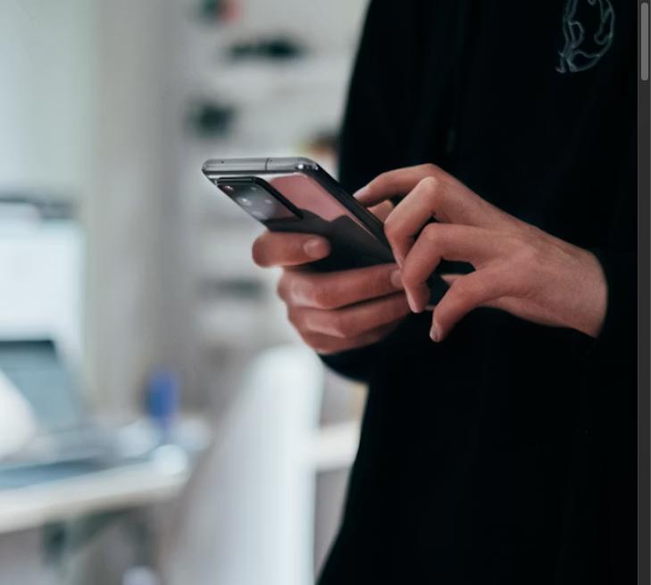 Person checking smartphone while waiting for a response
