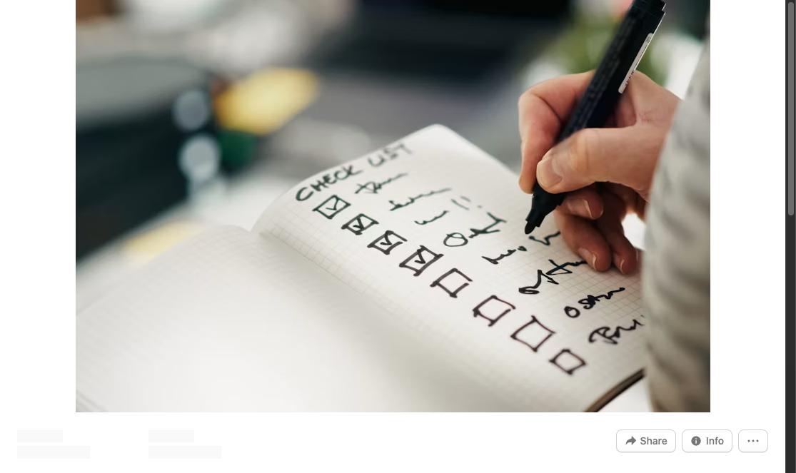 Person checking off items on a handwritten checklist in a notebook