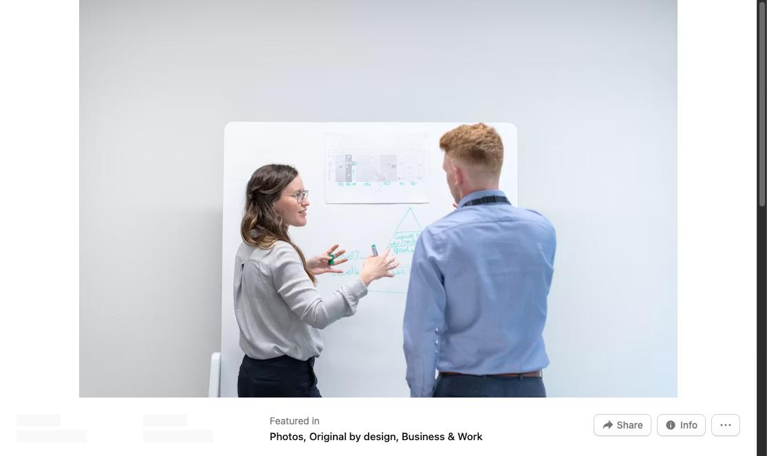 Two colleagues discussing ideas at a whiteboard in the office