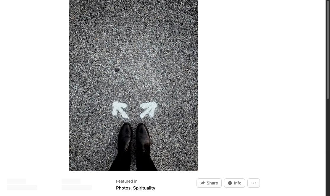Feet on asphalt standing between two arrows pointing in different directions, symbolizing a career decision