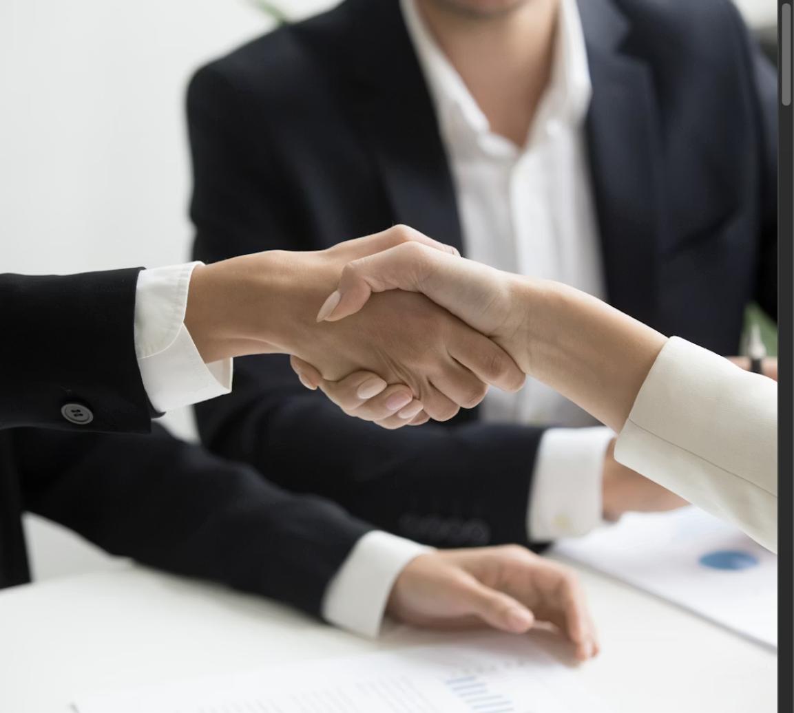 Two professionals shaking hands during a salary negotiation discussion