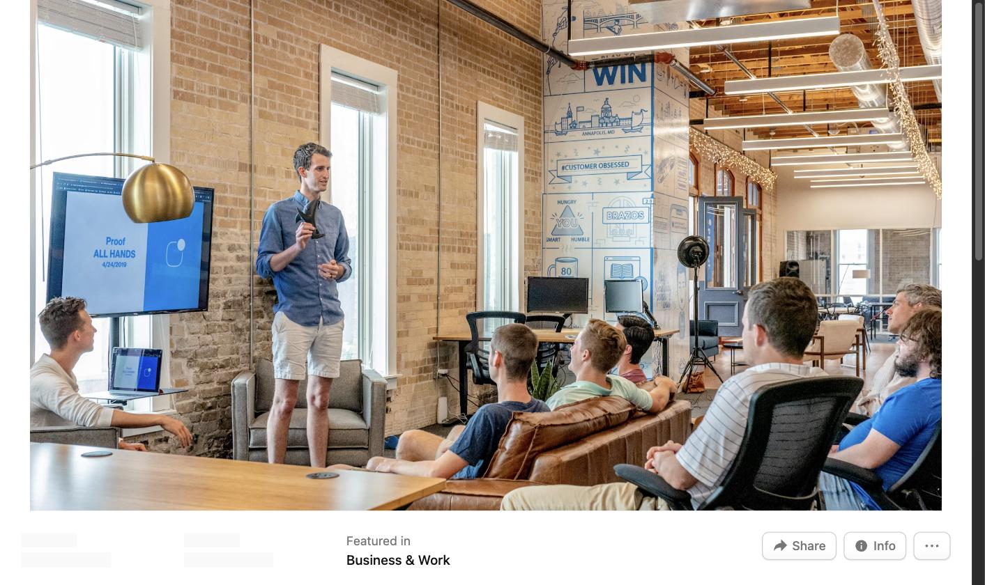 Man standing and presenting to a group of colleagues on a screen in an office