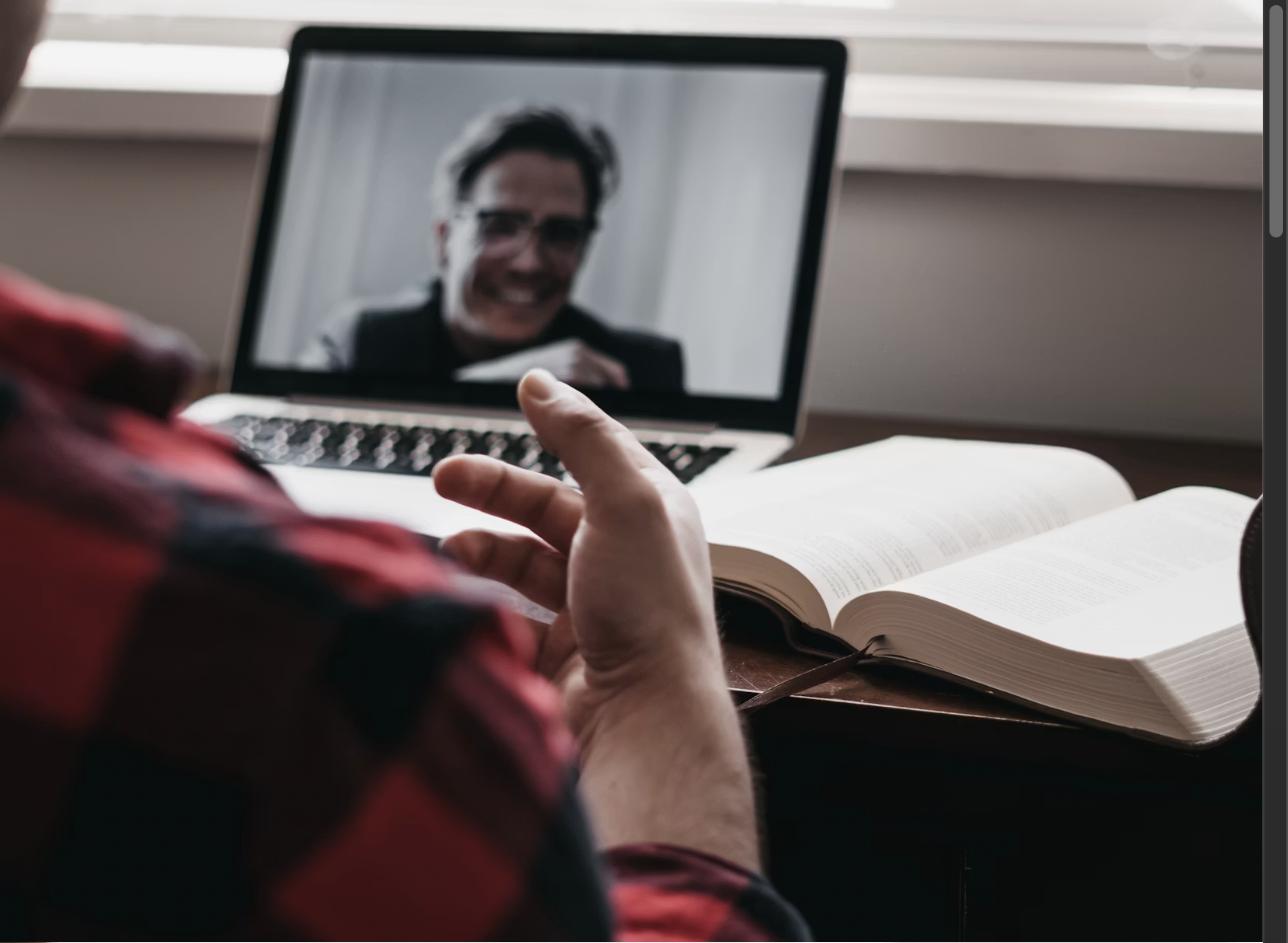 A person on a video call with a laptop at home, representing negotiating salary in a hybrid or remote work environment