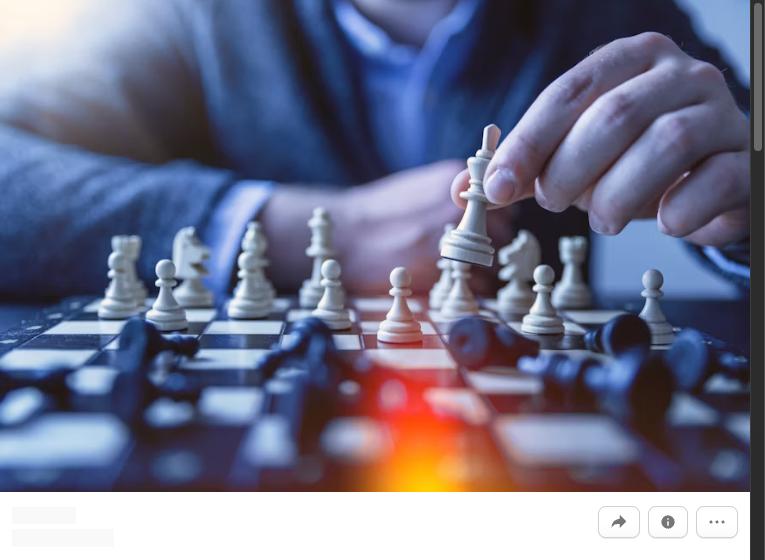 A close-up of a hand moving a chess piece, representing developing strategic thinking skills