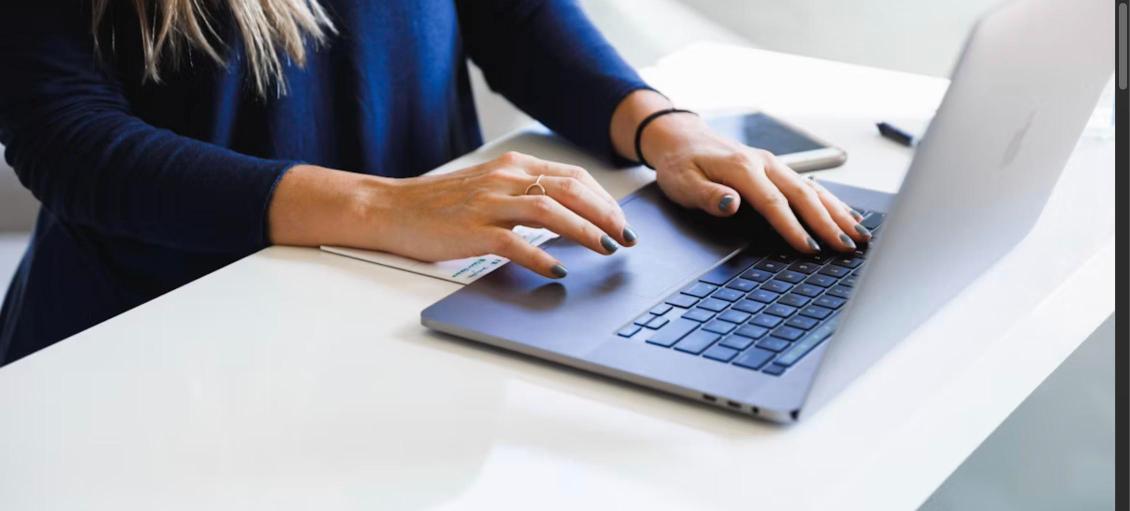 Woman typing on a laptop, representing writing a professional LinkedIn summary