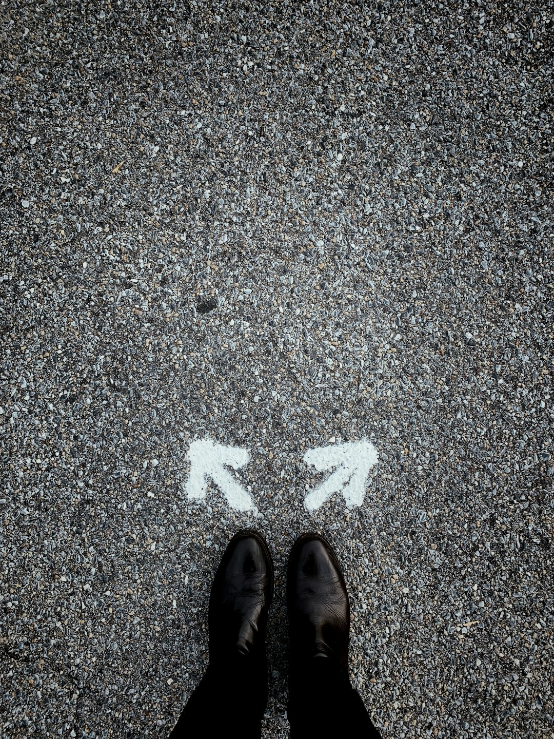 Feet standing between two directional arrows, representing a career change decision