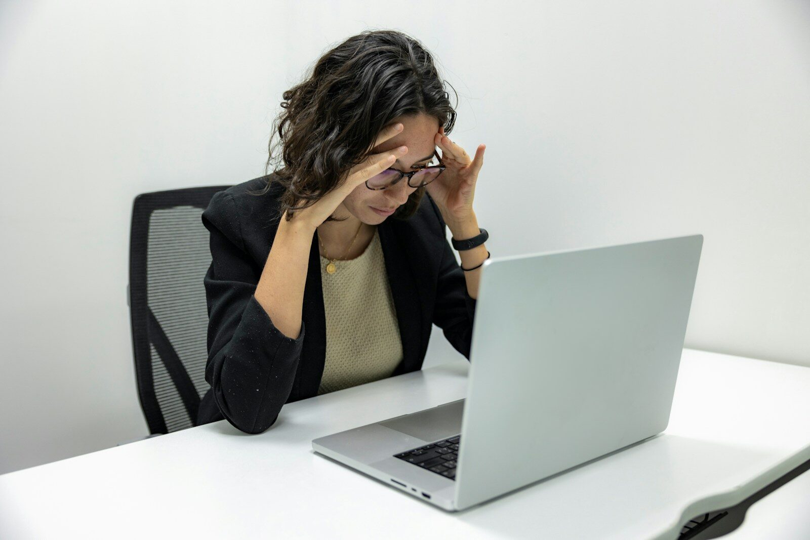 Frustrated woman looking at her laptop, representing a costly LinkedIn profile mistake