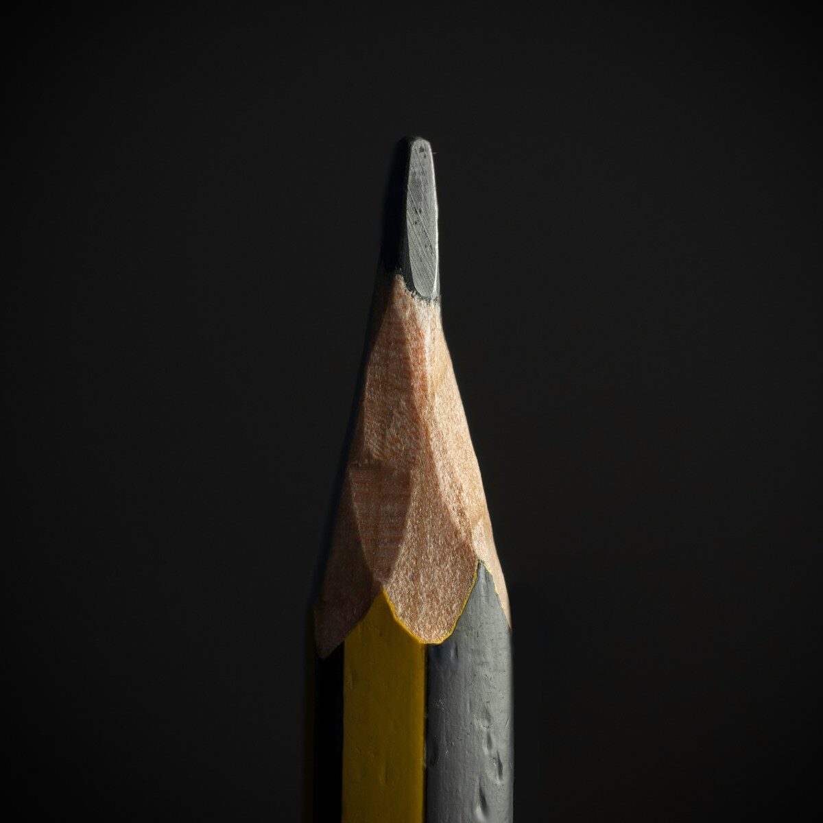 Sharpened pencil against a dark background, representing recovering and correcting a career mistake