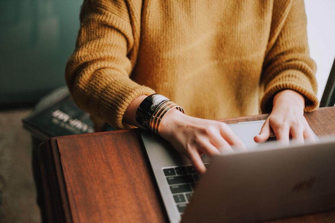 Person typing on a laptop while writing a cover letter