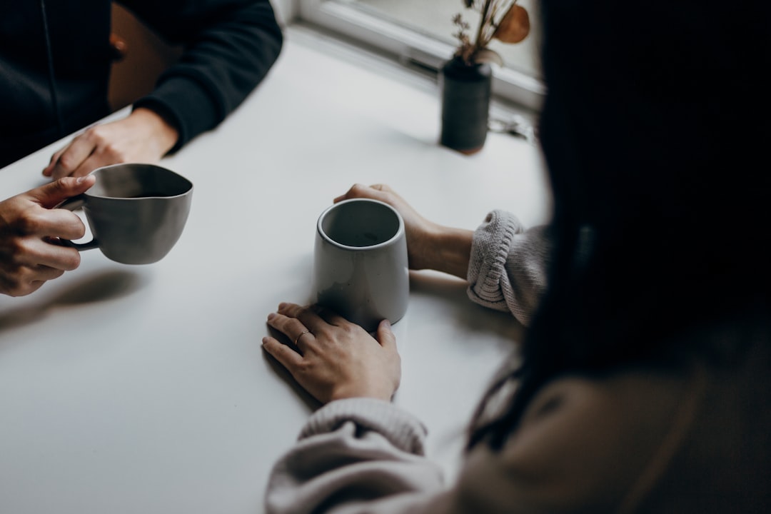 Two people having a casual conversation over coffee, representing an informational interview