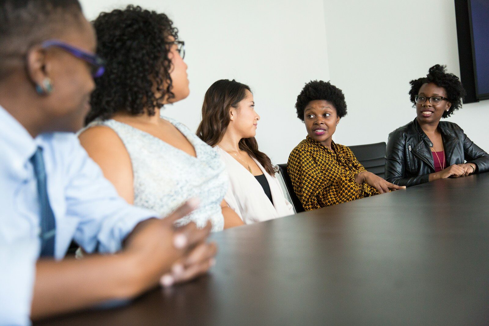 five people sitting at table and talking - prepare for a panel interview