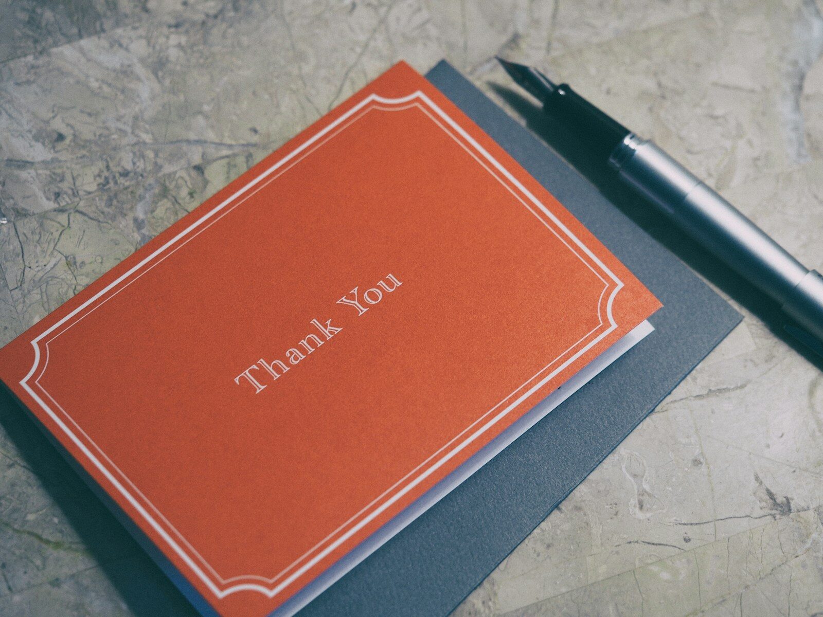 fountain pen next to red Thank You journal - thank you email after an interview