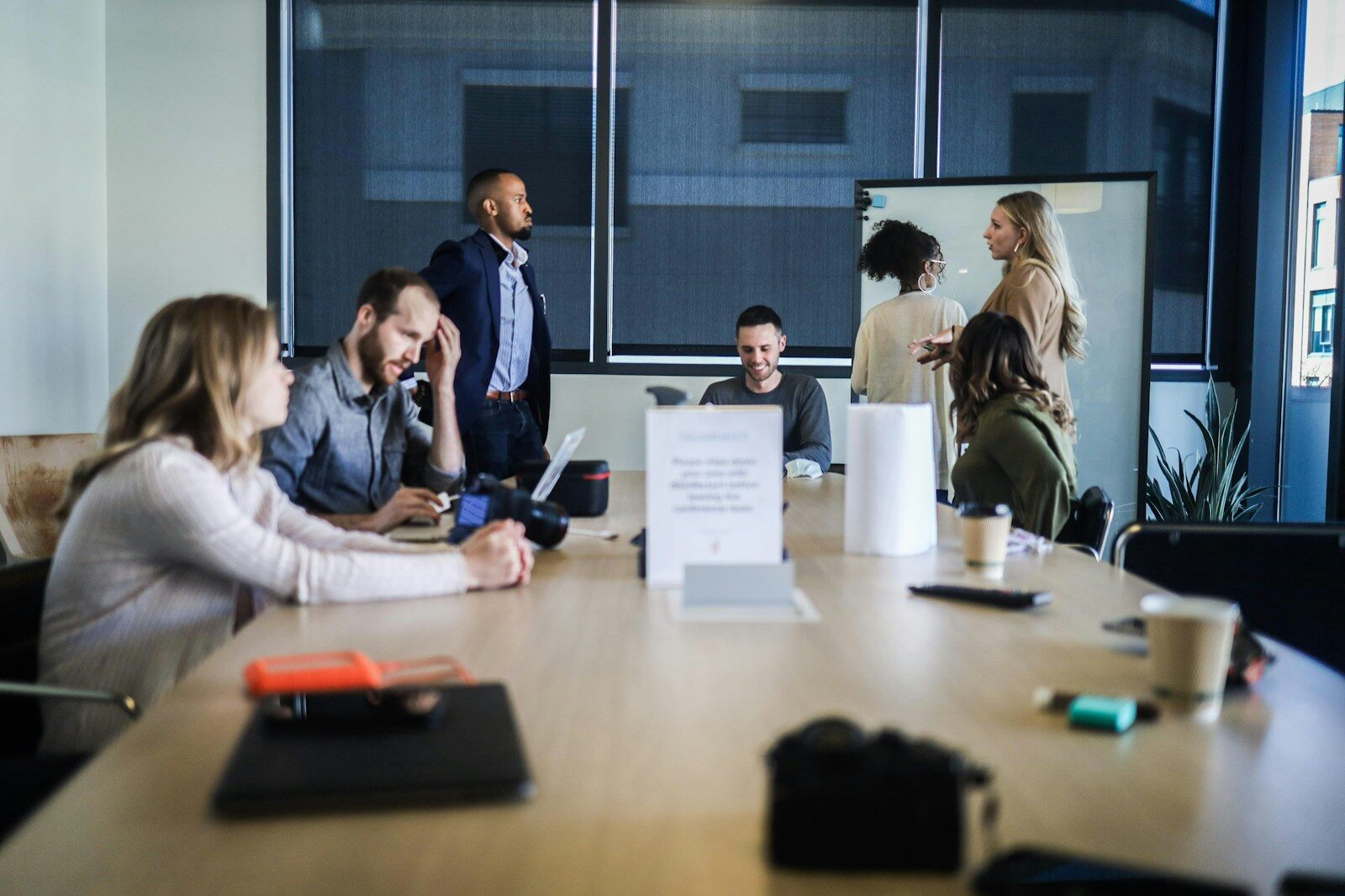 Small business jobs: a small team of colleagues gathered around a conference table discussing work, illustrating the close-knit HR dynamics of a small company