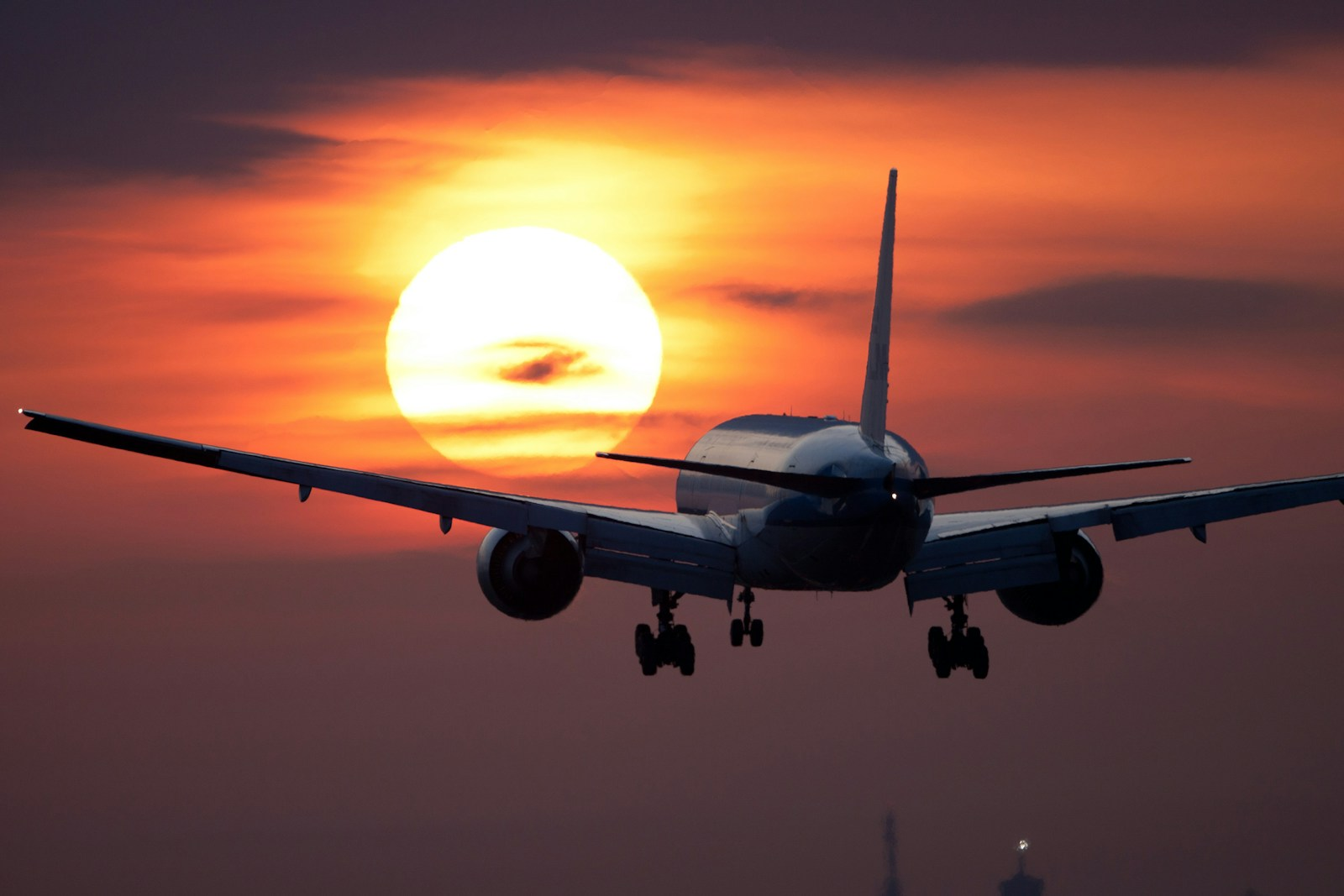 Become a pilot: a commercial jet on final approach silhouetted against a sunset, representing the airline pilot career many student pilots are working toward