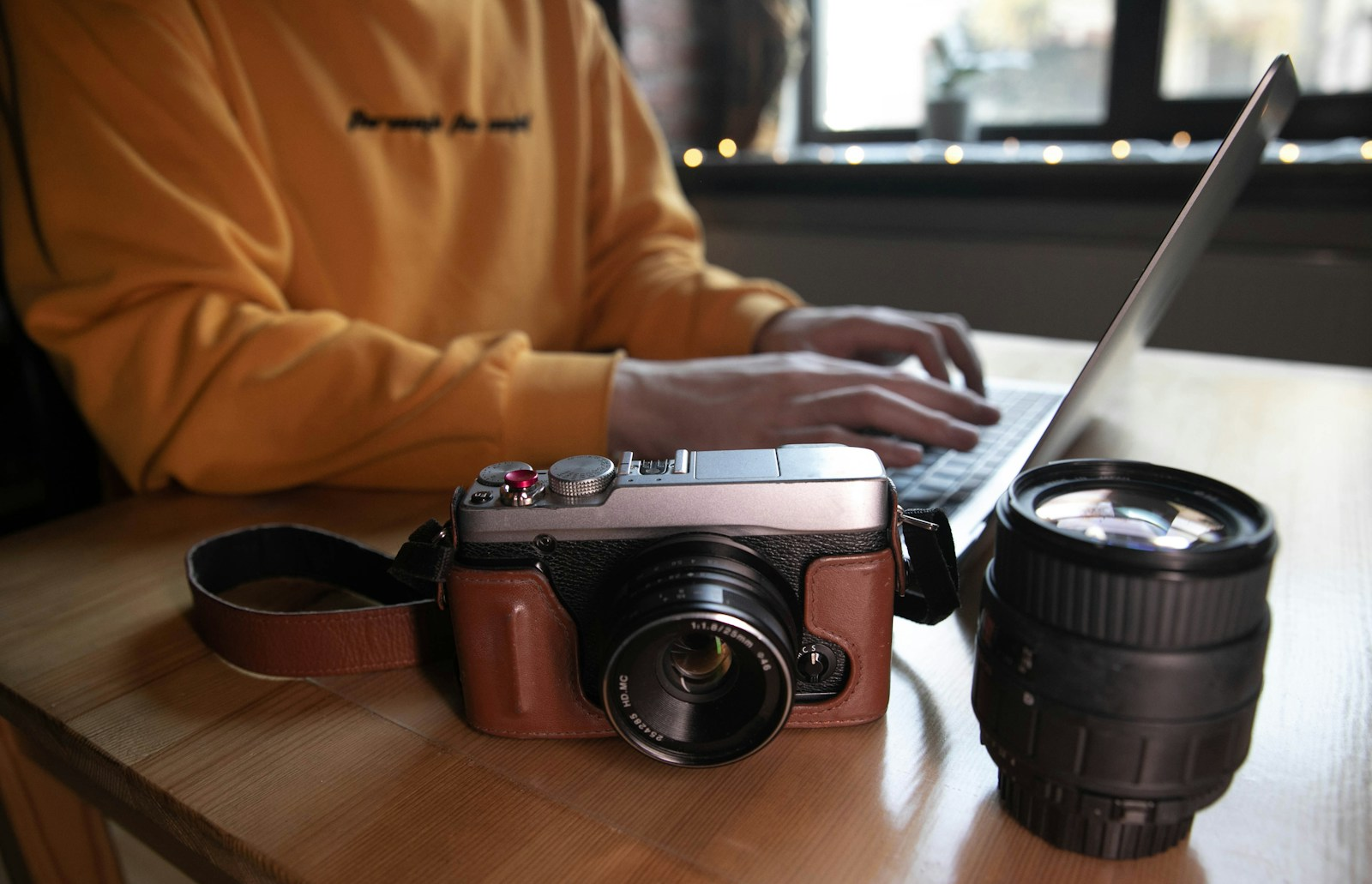 Break into multimedia: a freelancer editing on a laptop next to a camera, representing the independent-contractor reality common to multimedia careers