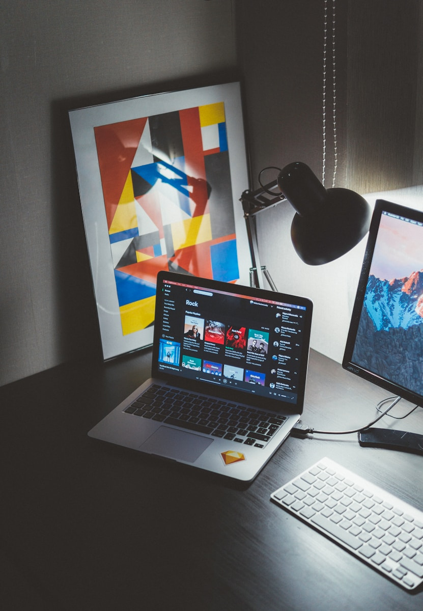 Break into multimedia: a creative workspace with an abstract art print and dual monitors, representing the design and animation software work at the center of a multimedia career