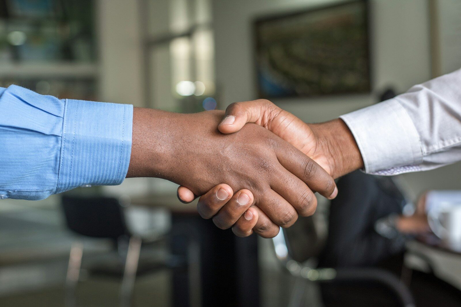Two professionals shaking hands, representing hiring one of many resume writing services
