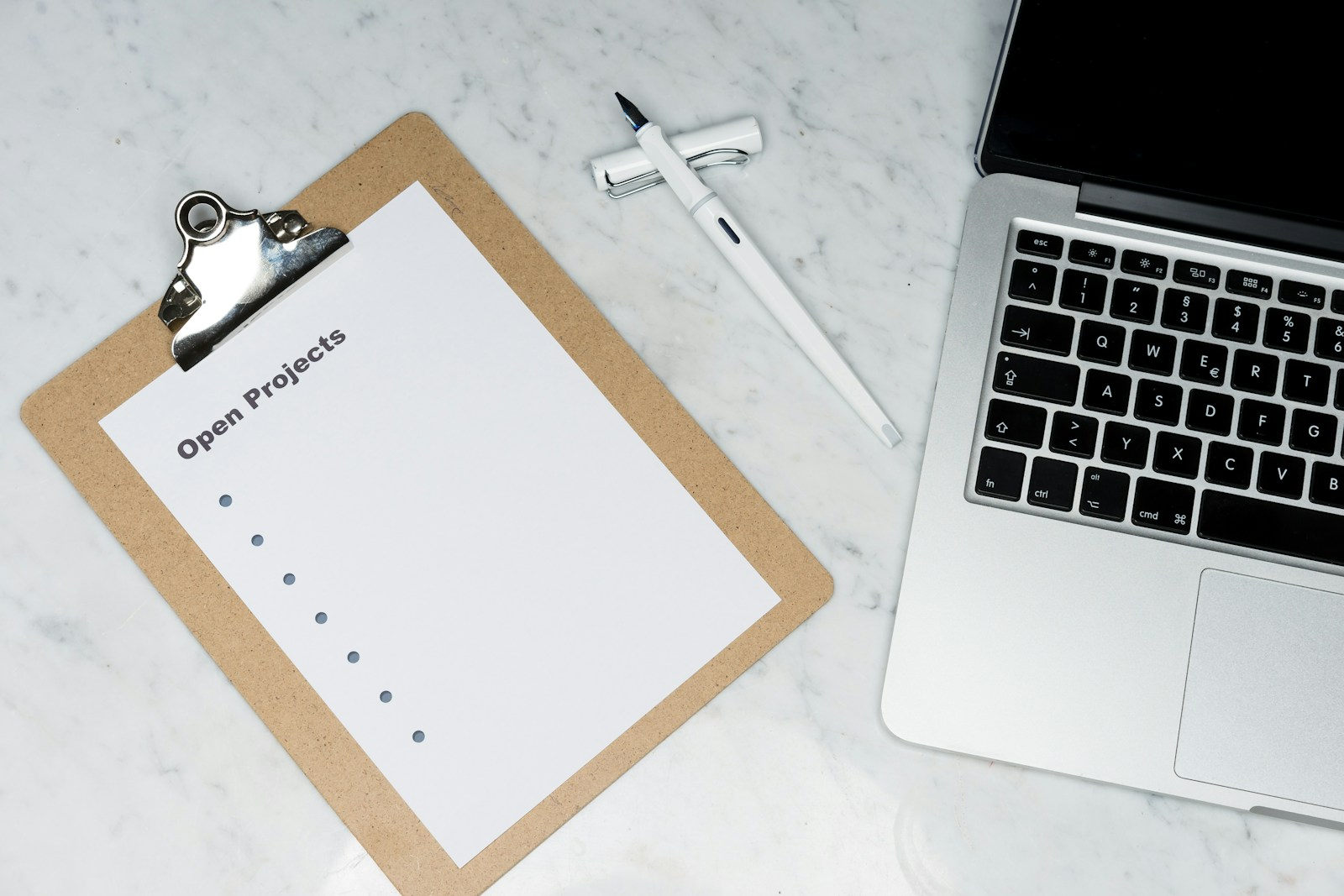 A tour or production manager checklist and clipboard next to a laptop