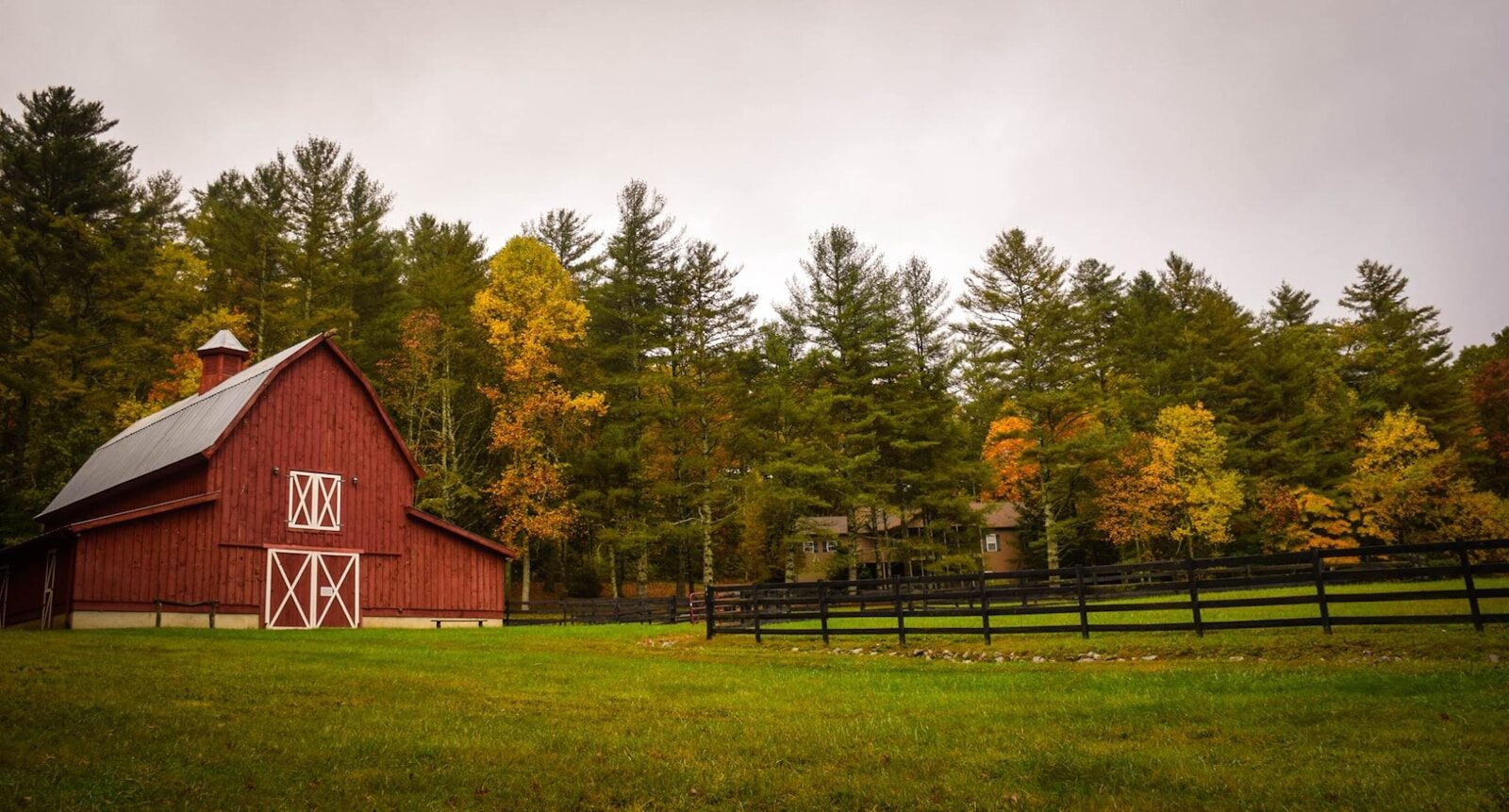 Become a farmer: a small red barn on a modest beginning farm property, illustrating the scale most new farmers start at before expanding