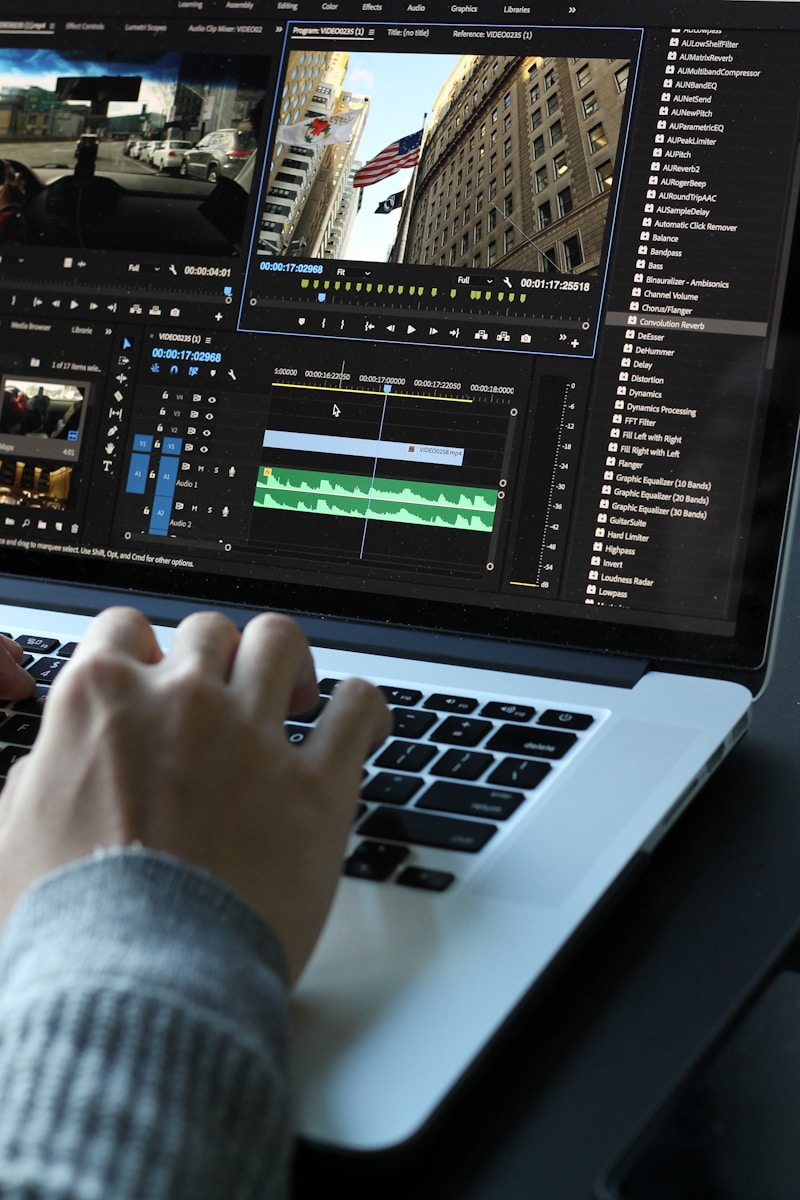 Break into multimedia: a hand editing video on a laptop with a colorful editing timeline visible, representing the hands-on software skills needed for a multimedia career