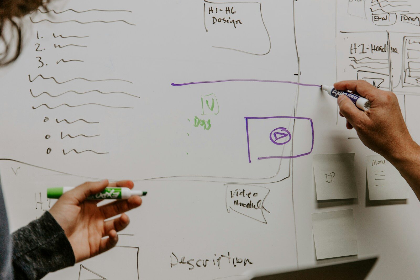 A person writing on a whiteboard planning a business strategy, representing the niche-selection step in becoming a business coach