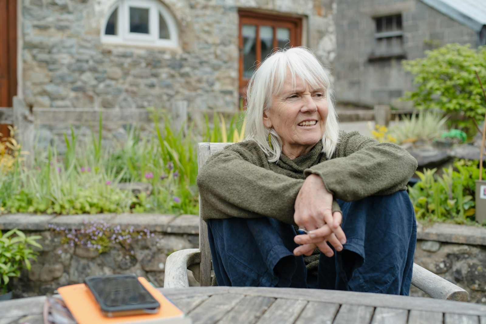 An older adult relaxing and smiling outdoors, illustrating the joy of retirement