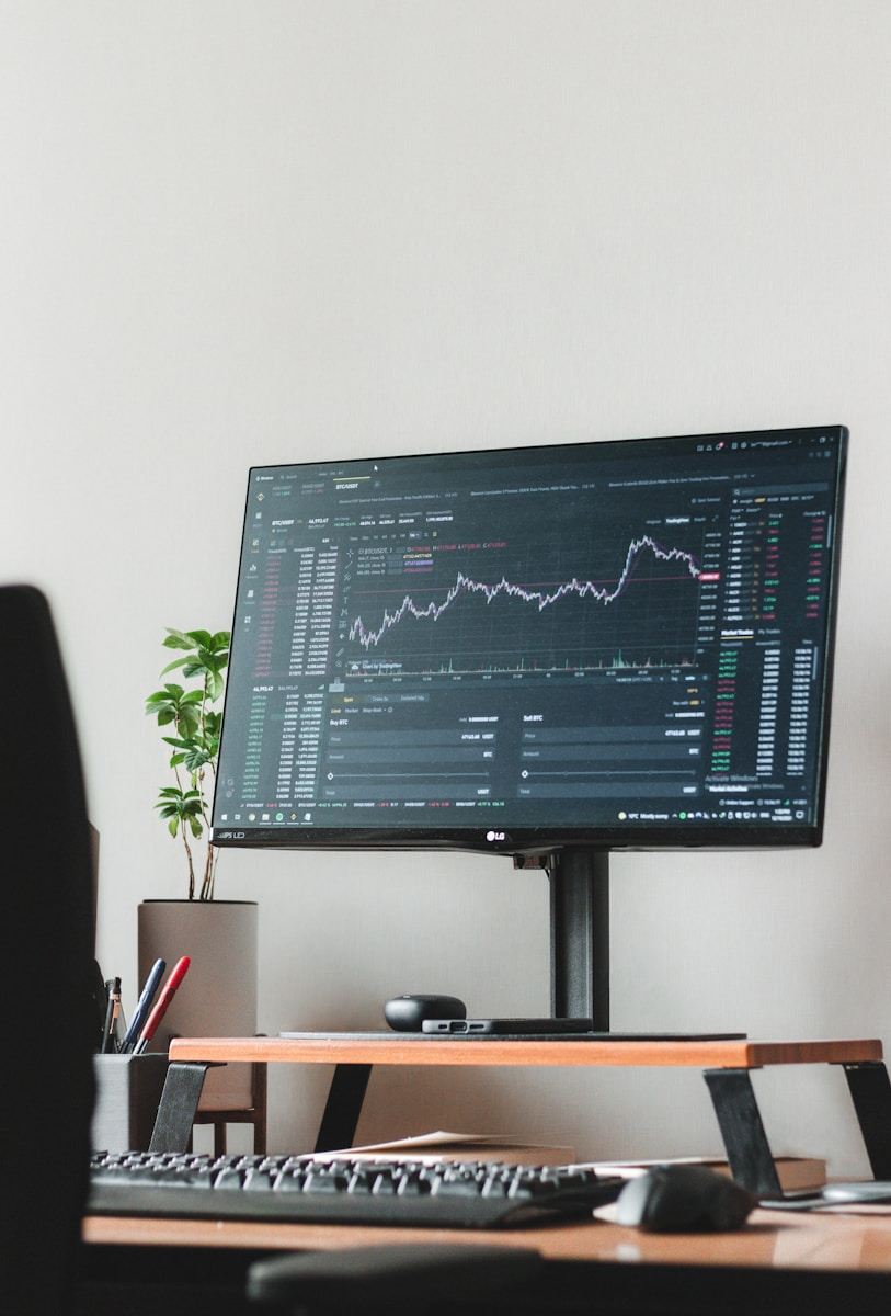 A trading desk with multiple monitors, representing funded trader programs in a forex trading career