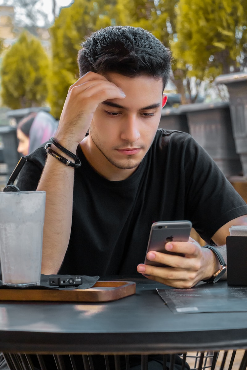 A reporter reading messages on a phone with a worried expression at a desk, weighing the stress and anxiety of a reporter