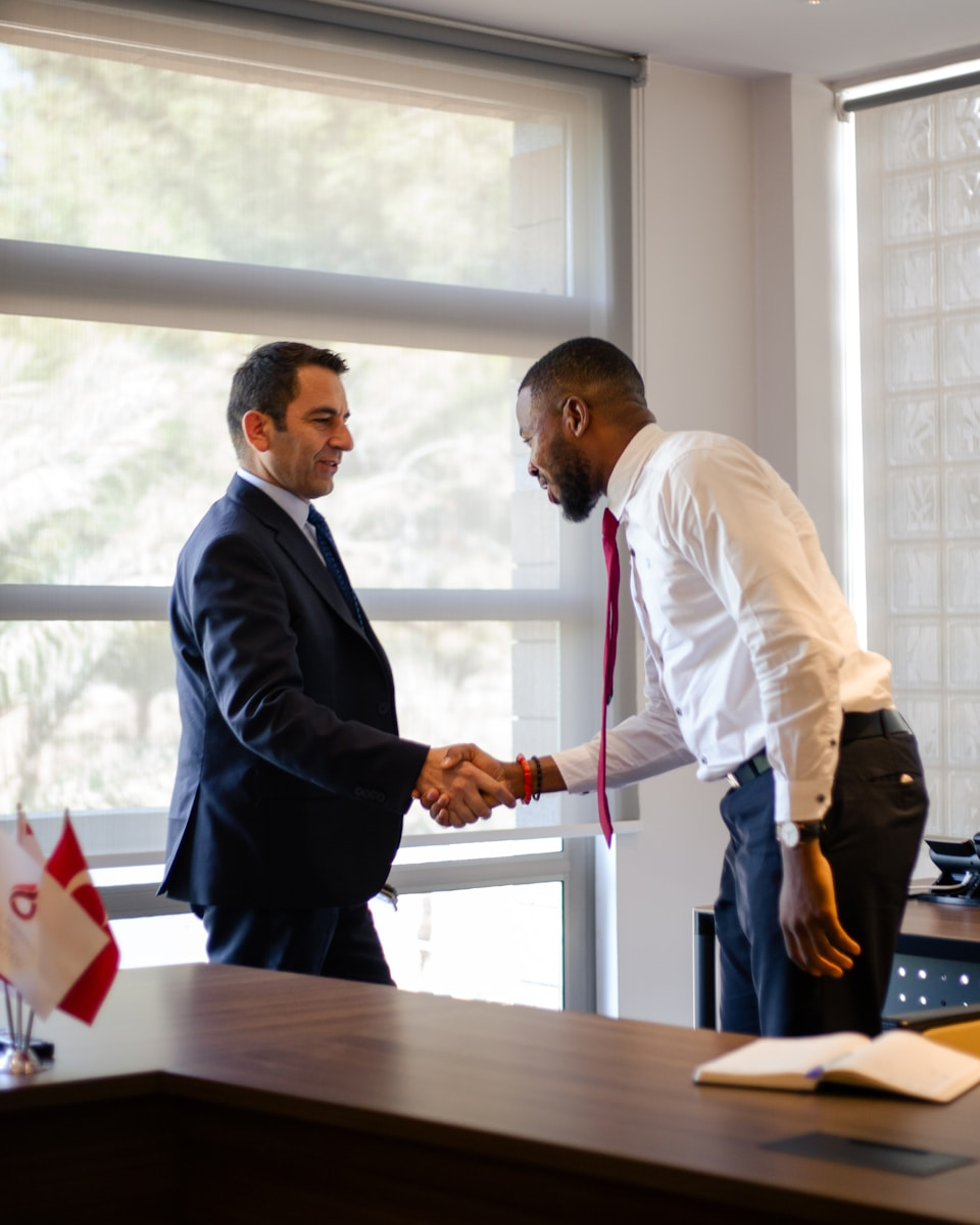 Two colleagues shaking hands in an office, representing the only way to resign well