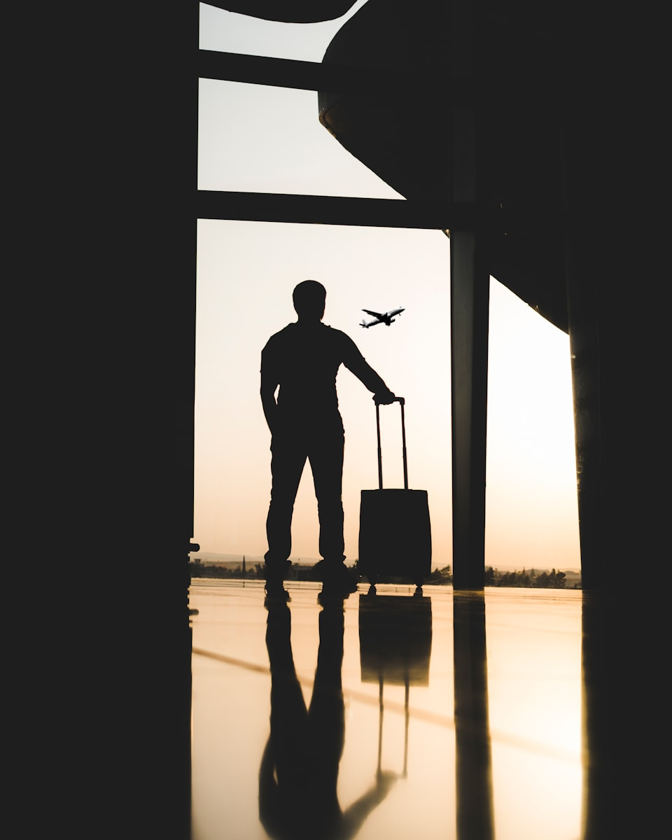 A traveler with luggage inside an airport, representing international relocation driven by the radiographer shortage