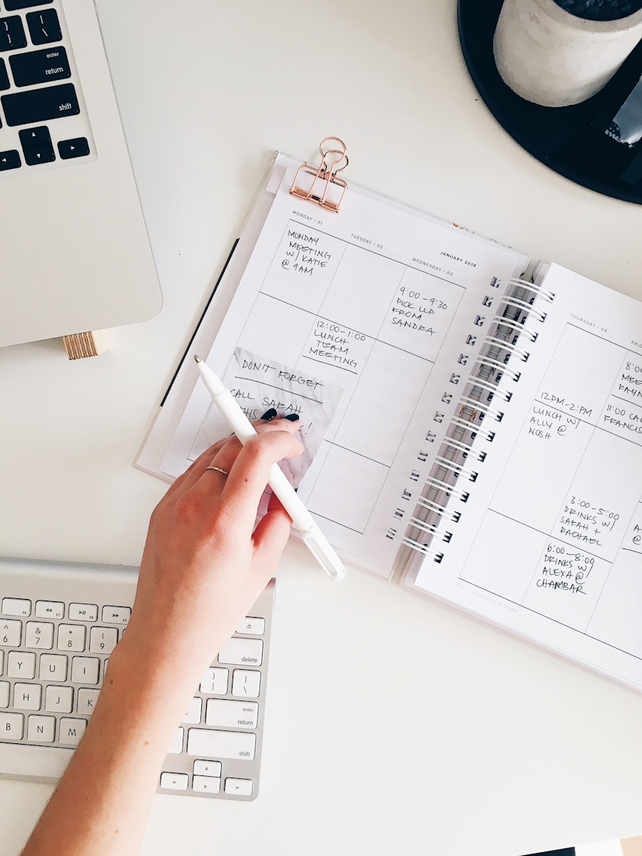 A person writing in a planner at a desk, illustrating the importance of goal setting for a career
