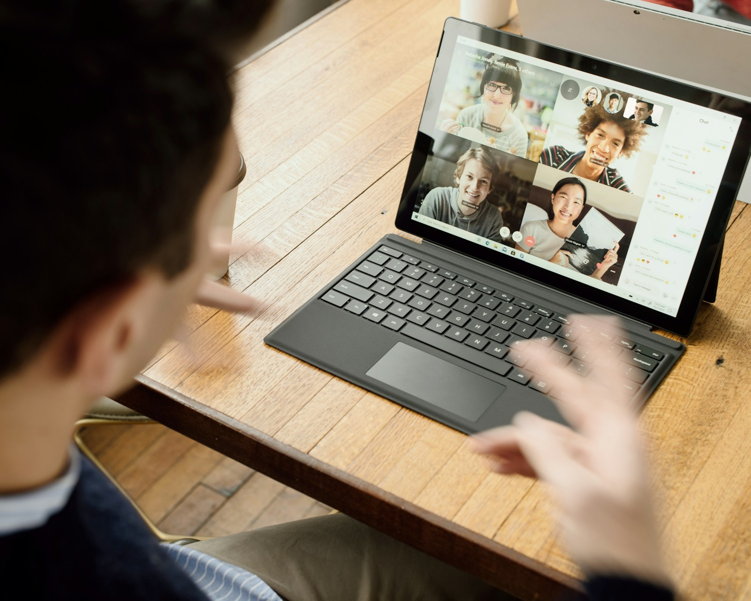 A person on a laptop video call with several students, representing the daily work involved in online tutor jobs