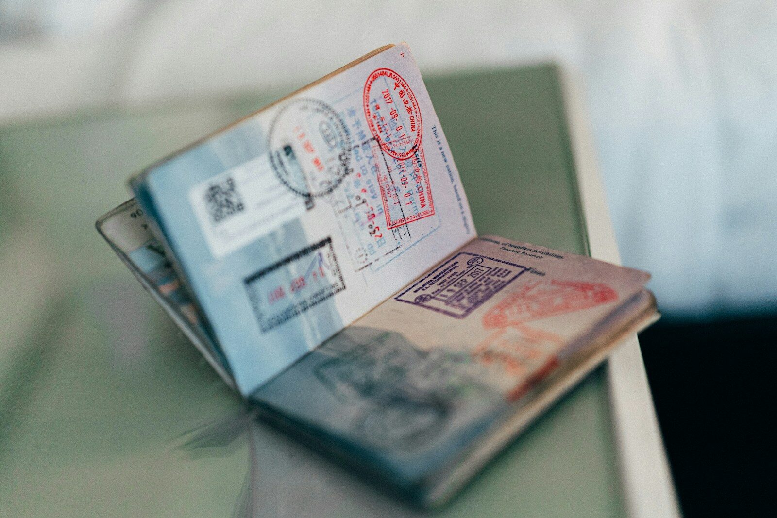 A passport with visa stamps and paperwork, representing the language and bureaucracy skills needed for life as an expat