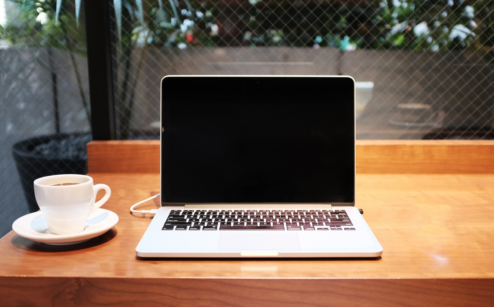 A laptop and coffee at a cafe table, representing how to make money online from anywhere