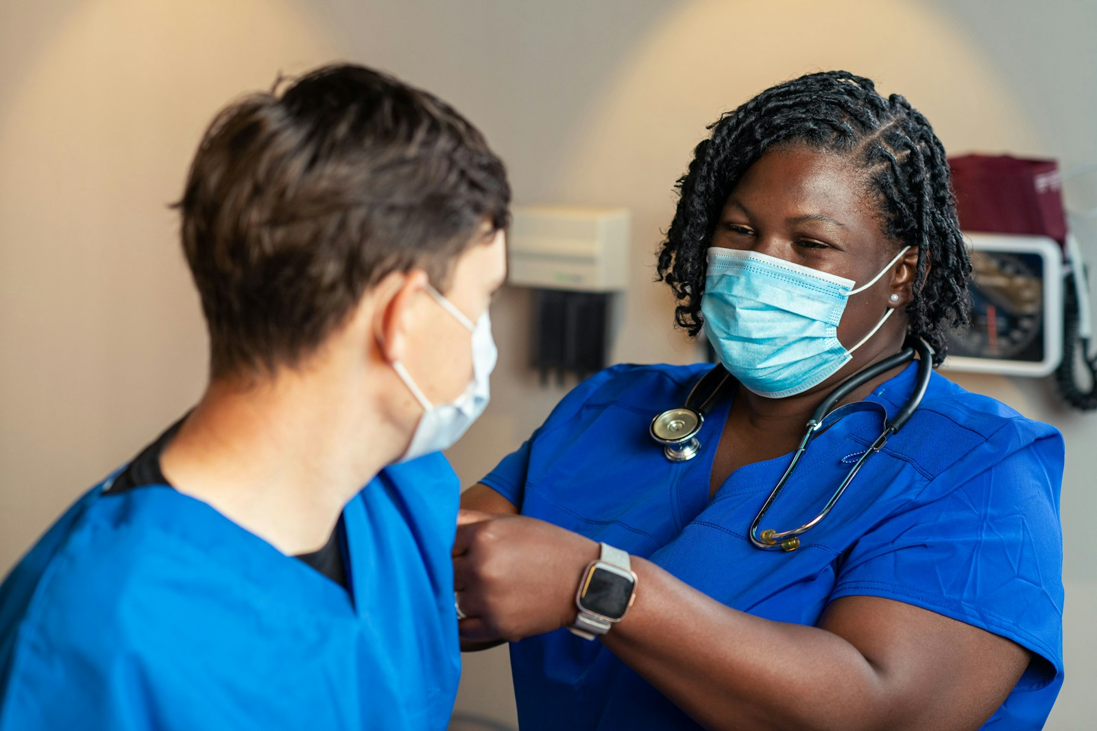 Two nurses in scrubs working together in a healthcare setting, thinking of an accelerated nursing program to further your career