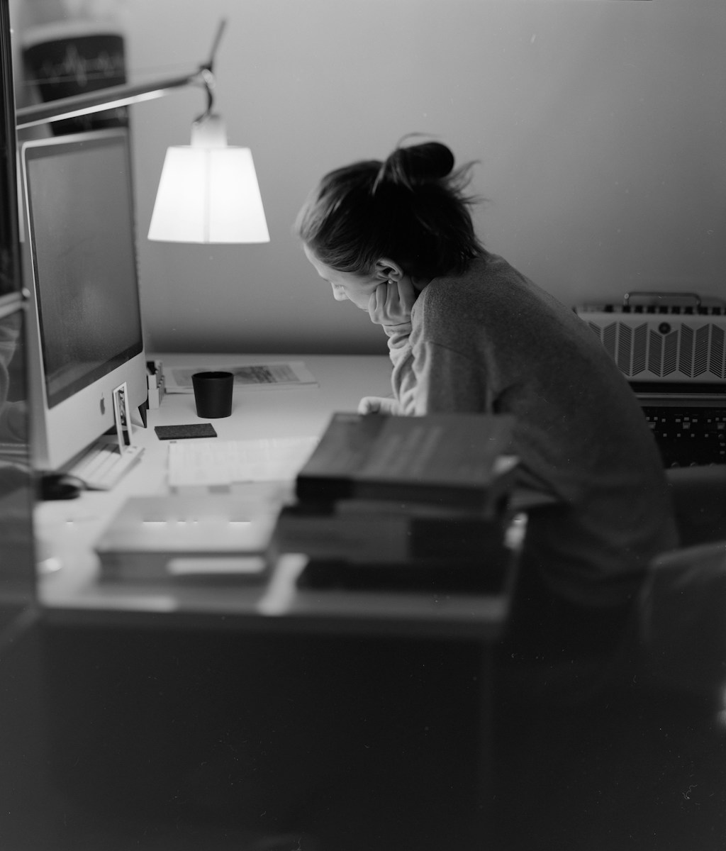 A person working late at a desk with a lamp, illustrating the demands of earning a doctorate degree