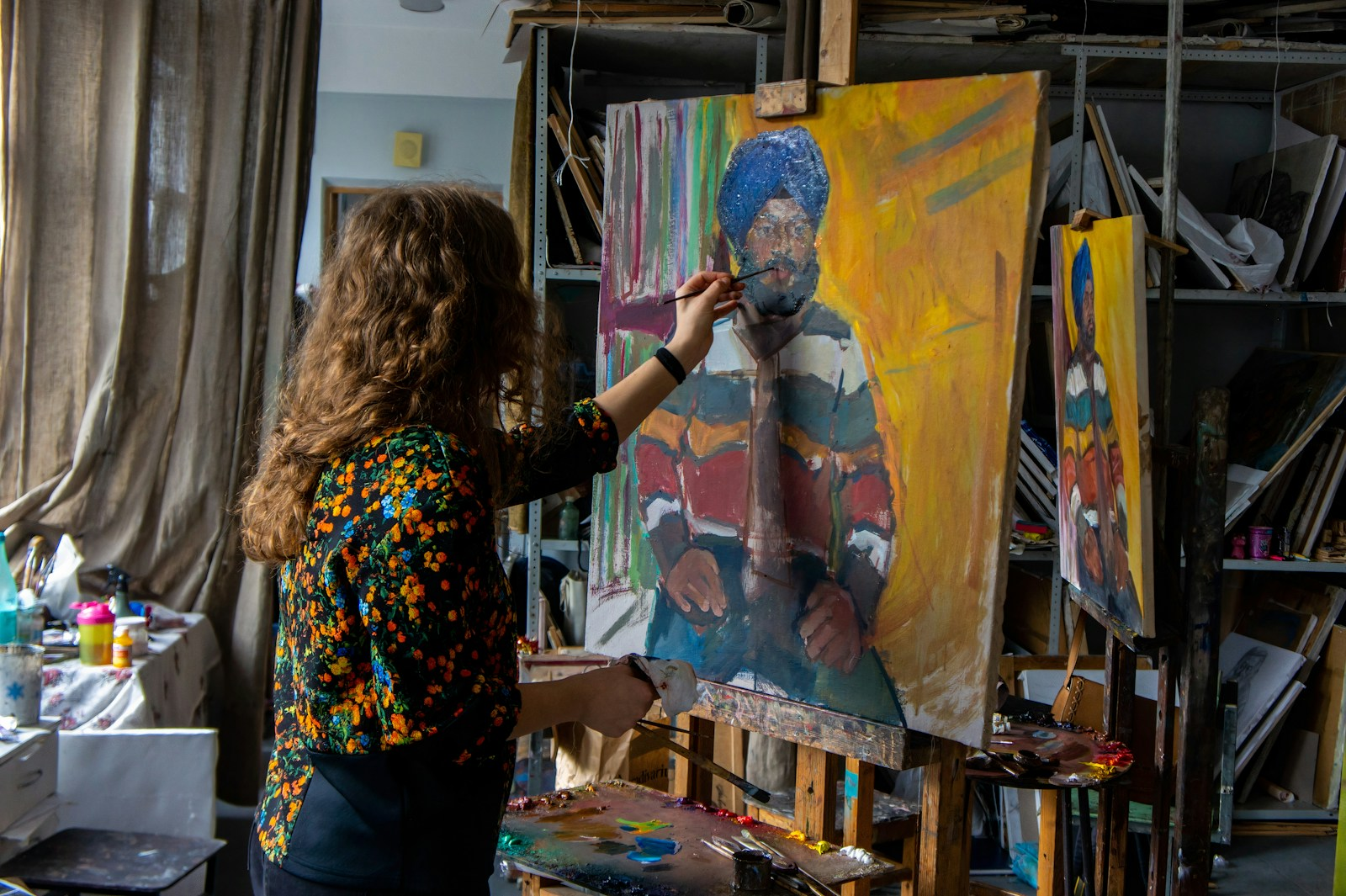 A painter working on a canvas in a studio, illustrating the joys of fame and no fortune
