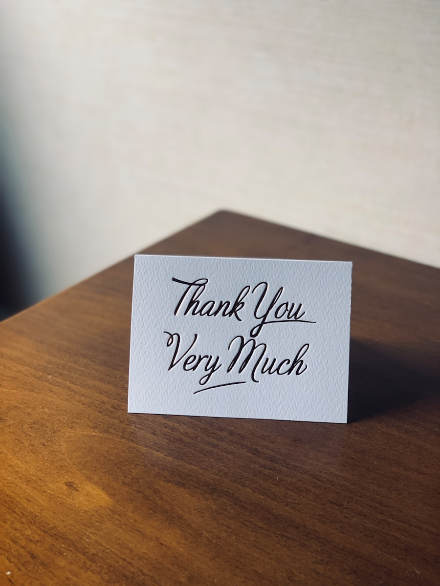 A handwritten thank you note on a desk, representing the process of saying thank you for hiring me to a new employer