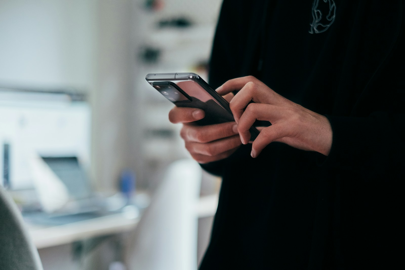 A person checking email on a phone, representing the concept of paid emails