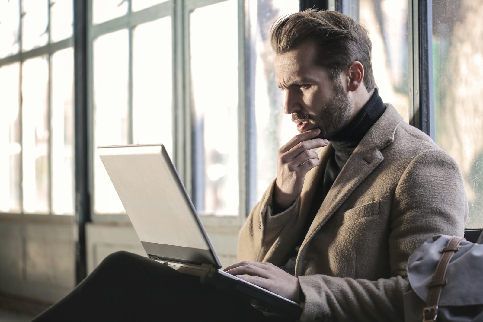 A person looking concerned while reviewing a laptop screen, illustrating red flags in the concept of paid emails