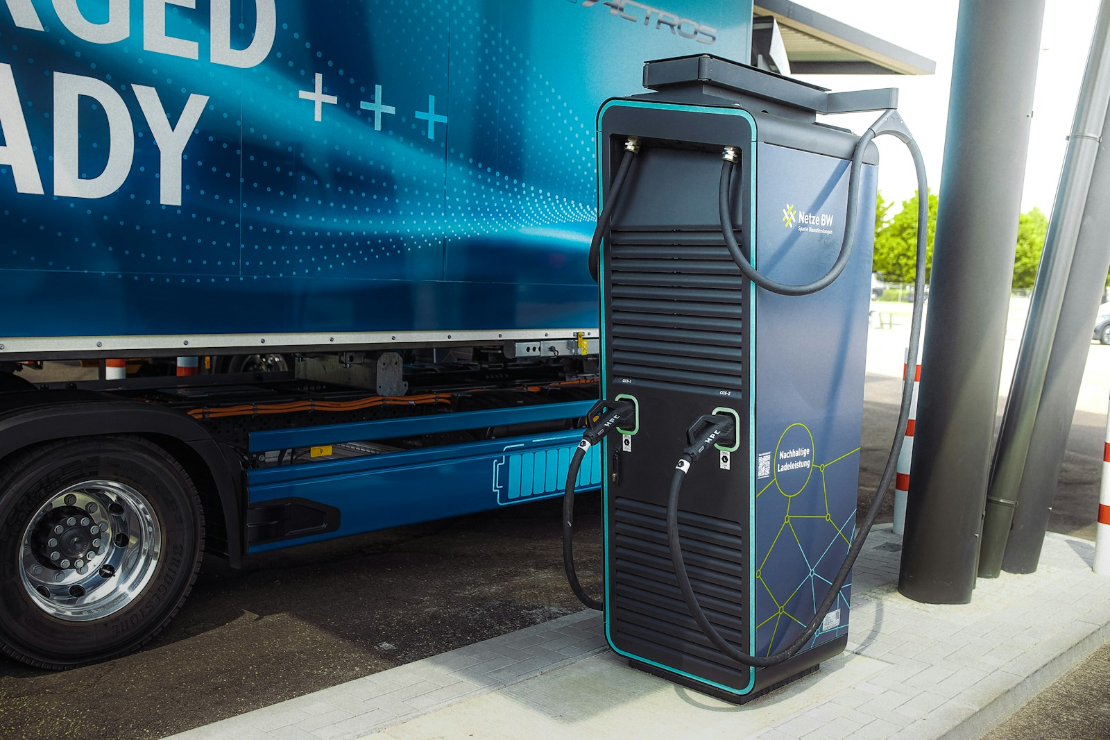 An electric semi truck charging, illustrating the slow shift toward electrification in the future of truck driving careers