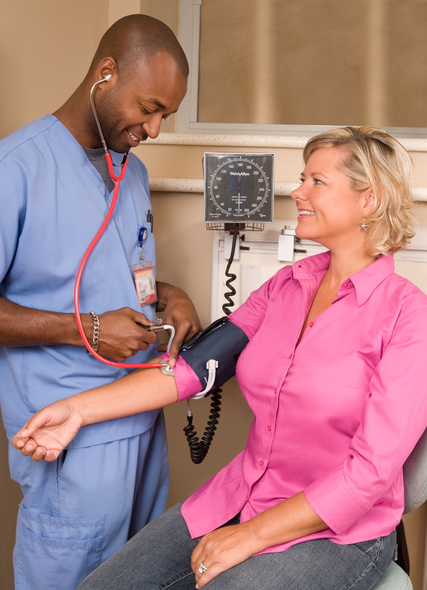 A nurse checking a patient's blood pressure, representing the many benefits of a nursing career