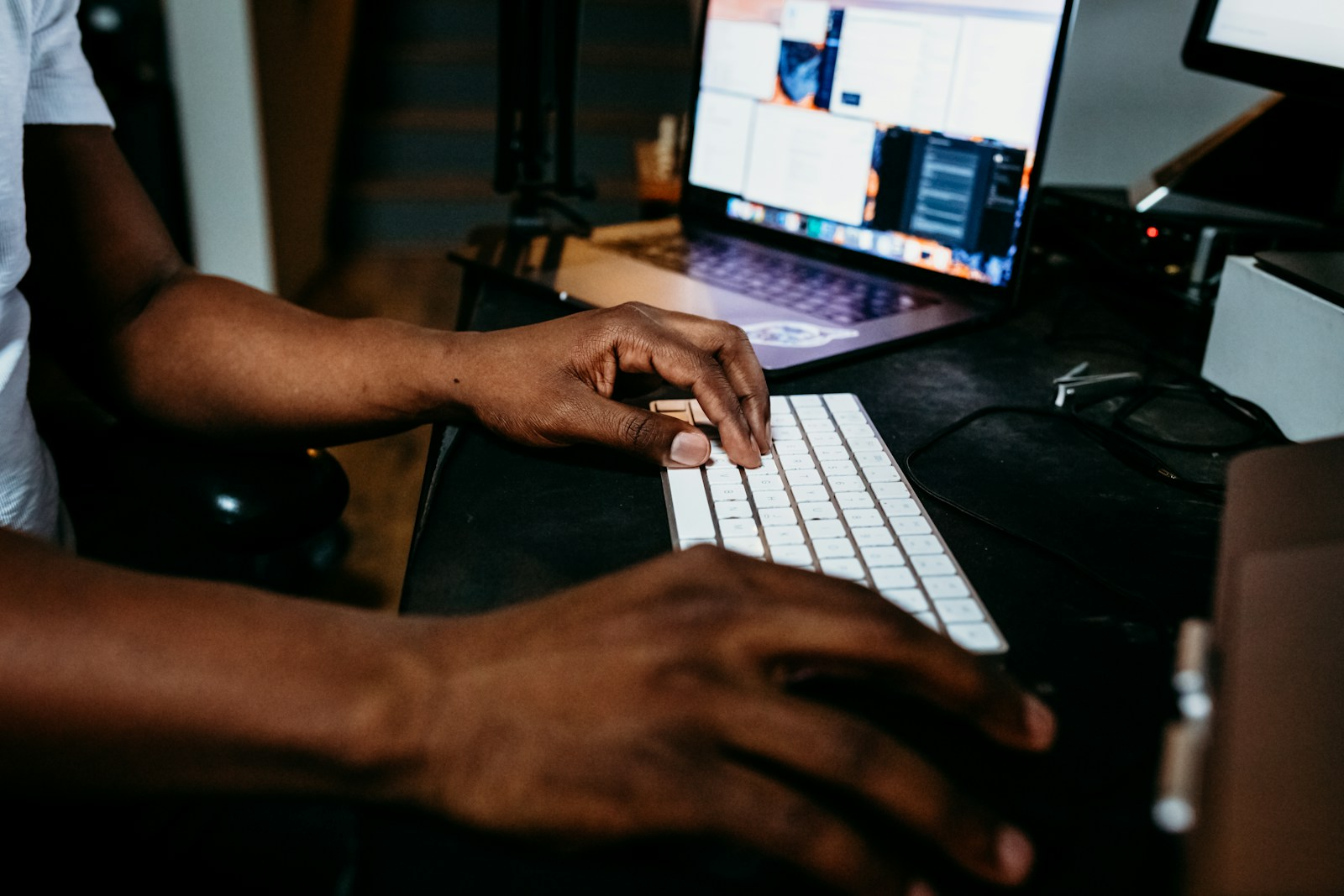 Close-up of hands typing on a laptop keyboard, representing the fonts and bullet points that affect ATS resume formatting