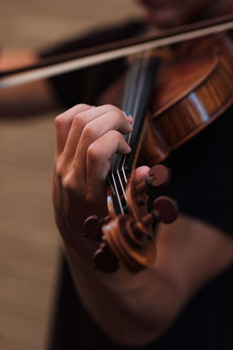 A student practicing violin during a private lesson, representing private music teacher jobs